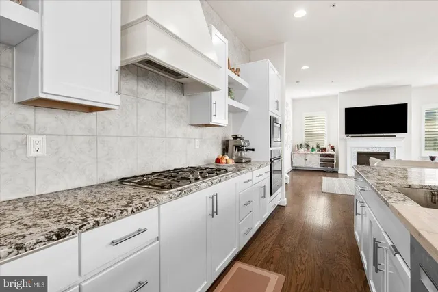 a kitchen with granite countertop a sink stove and cabinets