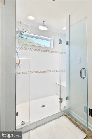 a bathroom with a shower and a glass door