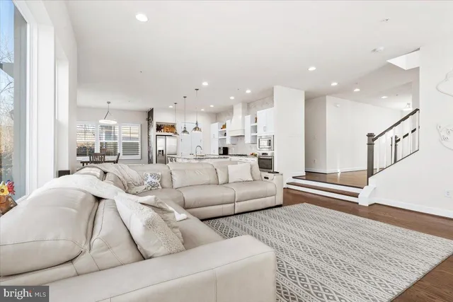 a large living room with stainless steel appliances kitchen island granite countertop furniture and a couch