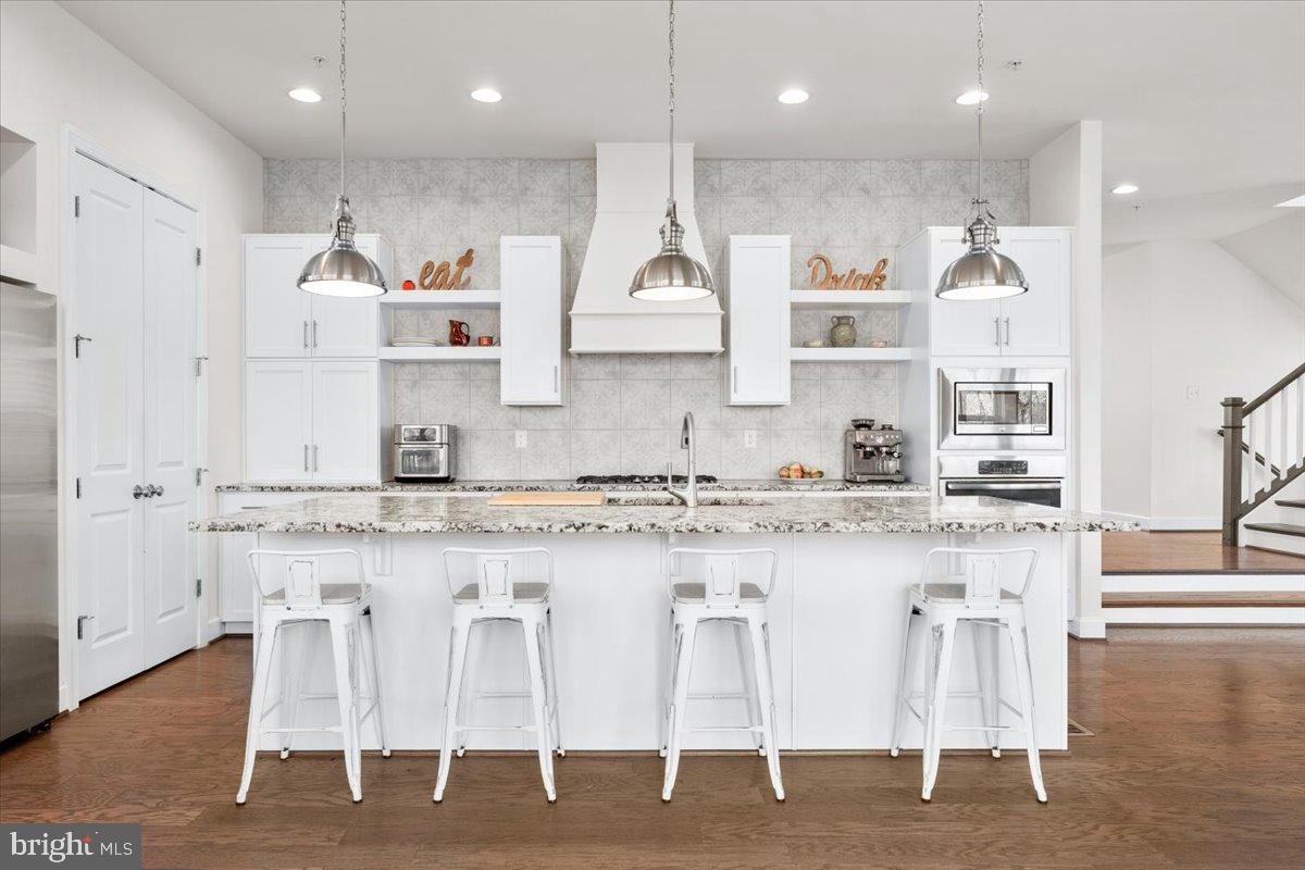 6828 West Shavano Road New Market, MD 21774 - Photo 9 of 58 a large kitchen with granite countertop lots of white cabinets and stainless steel appliances