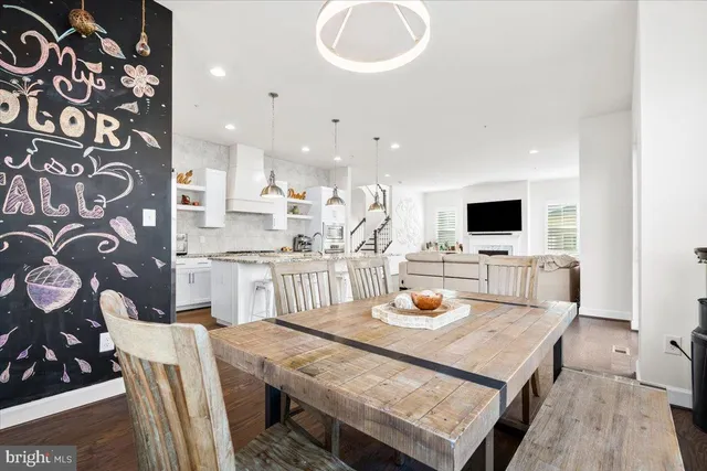 a kitchen with stainless steel appliances a dining table and chairs