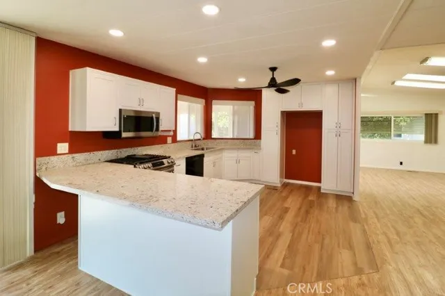 a kitchen with stainless steel appliances granite countertop a sink a stove and a refrigerator