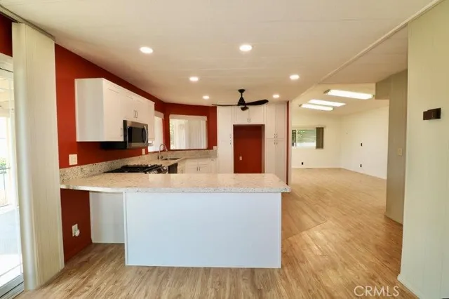 a view of kitchen with kitchen island granite countertop a sink a stove and a refrigerator