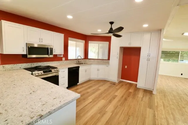 a kitchen with stainless steel appliances granite countertop a stove a sink and a refrigerator