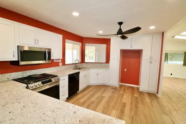 a kitchen with stainless steel appliances kitchen island granite countertop a stove and a sink