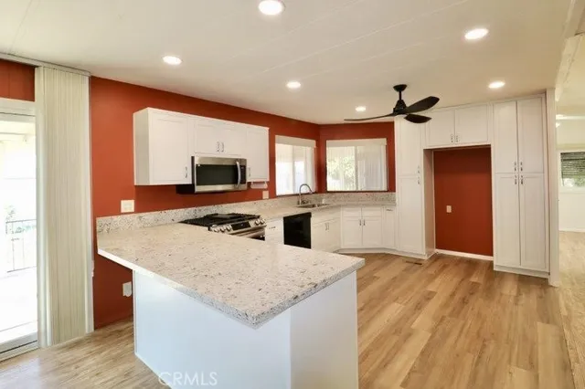 a kitchen with a sink a counter top space stainless steel appliances and a window
