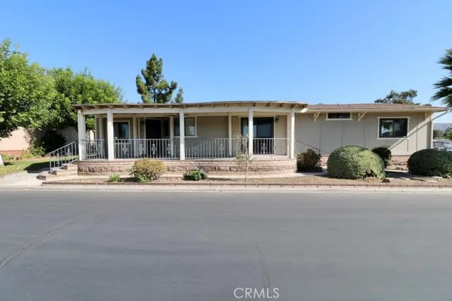 a front view of a house with yard and parking