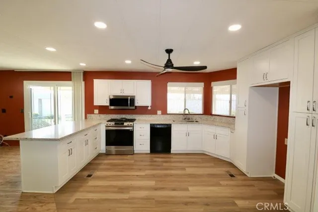 a large kitchen with stainless steel appliances granite countertop a stove and a refrigerator