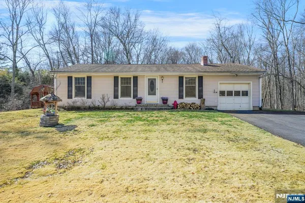 a front view of house with yard and trees around