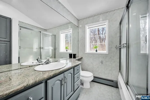 a bathroom with a granite countertop sink toilet and shower