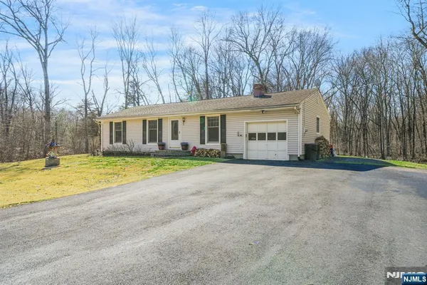 a view of an house with backyard and parking