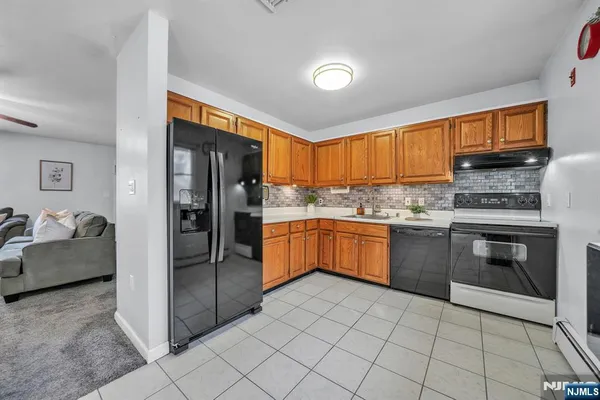 a kitchen with stainless steel appliances granite countertop a stove top oven a refrigerator and a sink