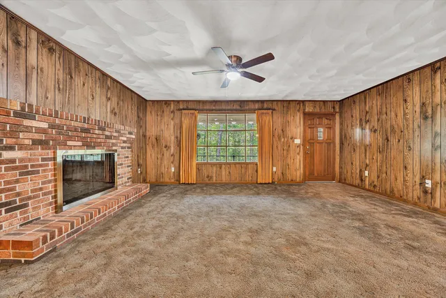 an empty room with windows and fireplace