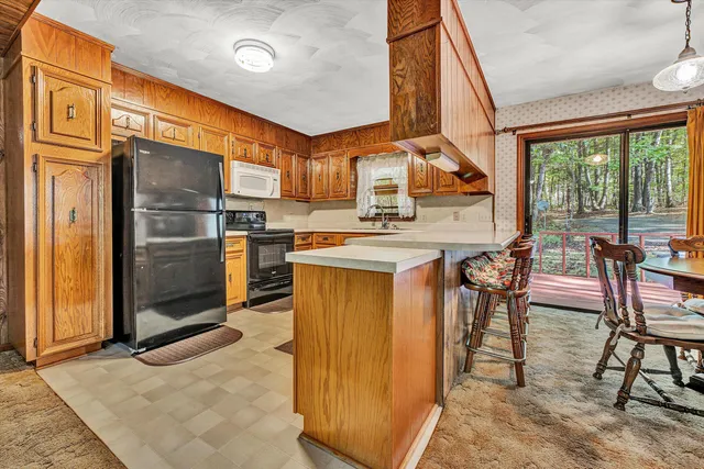a kitchen with stainless steel appliances granite countertop a stove top oven a sink and a refrigerator
