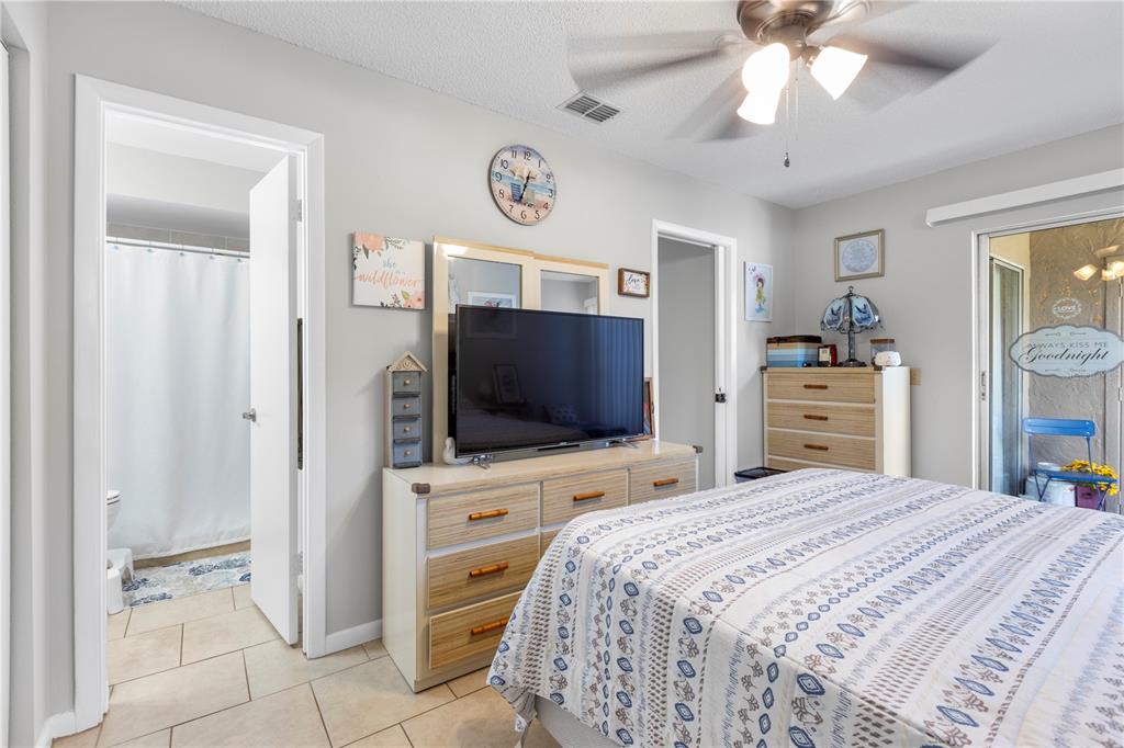 22751 Penny Loop Land O' Lakes, FL 34639 - Photo 12 of 27 a bedroom with a bed and a flat screen tv