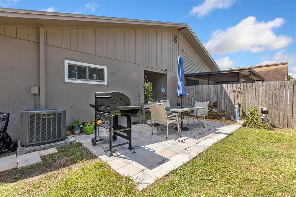 22751 Penny Loop Land O' Lakes, FL 34639 - Photo 17 of 27 a view of a backyard with table and chairs with wooden fence