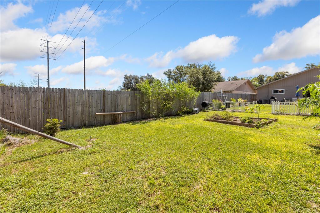 22751 Penny Loop Land O' Lakes, FL 34639 - Photo 21 of 27 a swimming pool with yard and wooden fence