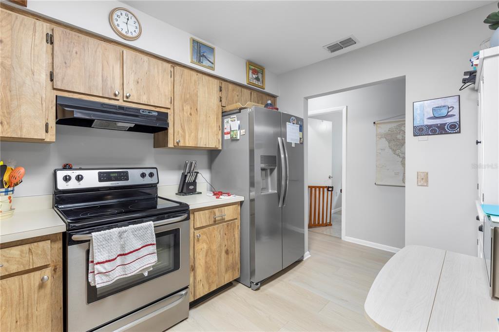 22751 Penny Loop Land O' Lakes, FL 34639 - Photo 8 of 27 a kitchen with stainless steel appliances granite countertop a refrigerator a stove and a sink