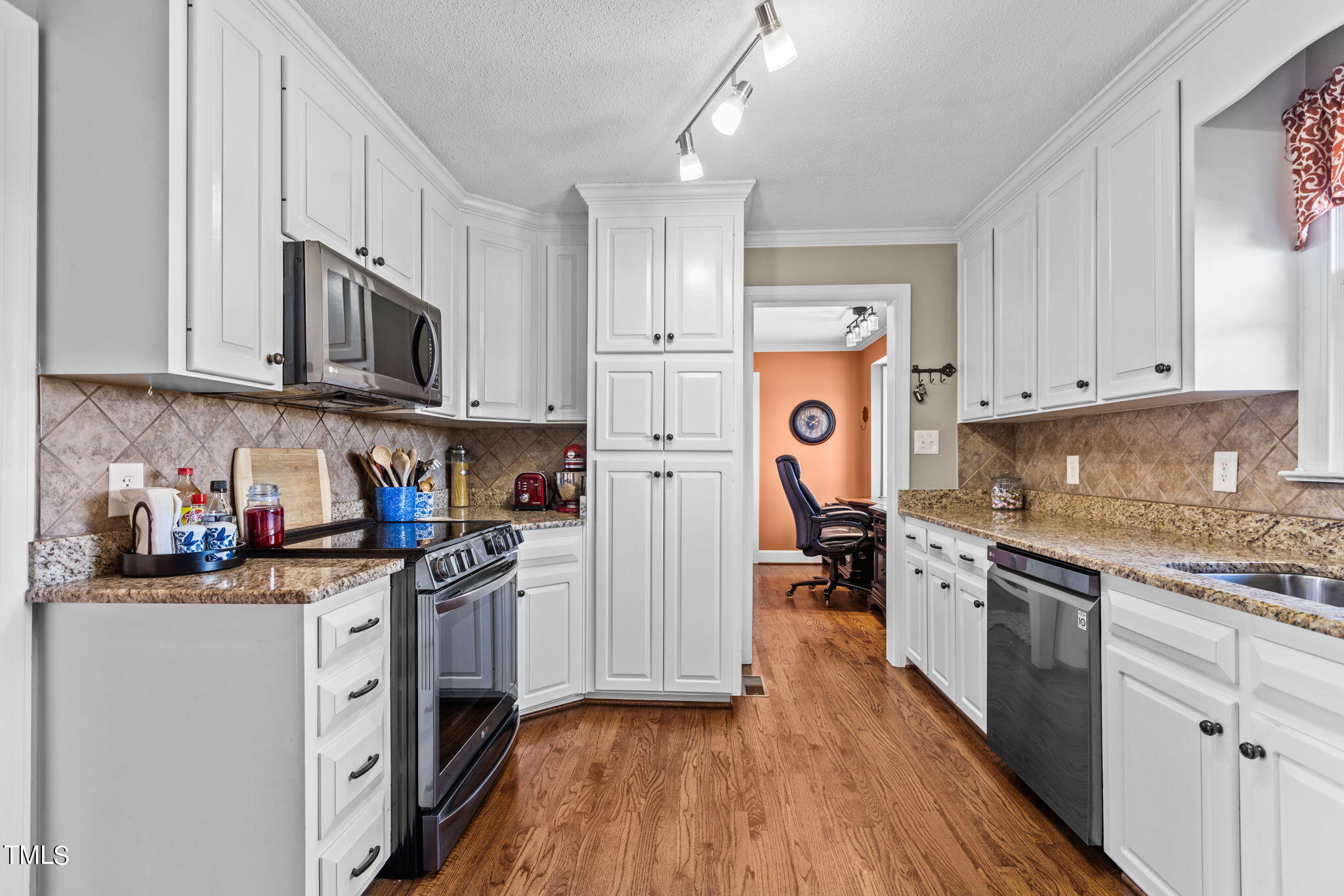 7980 Meadowbrook Road Benson, NC 27504 - Photo 17 of 56 a kitchen with stainless steel appliances granite countertop a stove top oven a refrigerator a sink and dishwasher with white cabinets