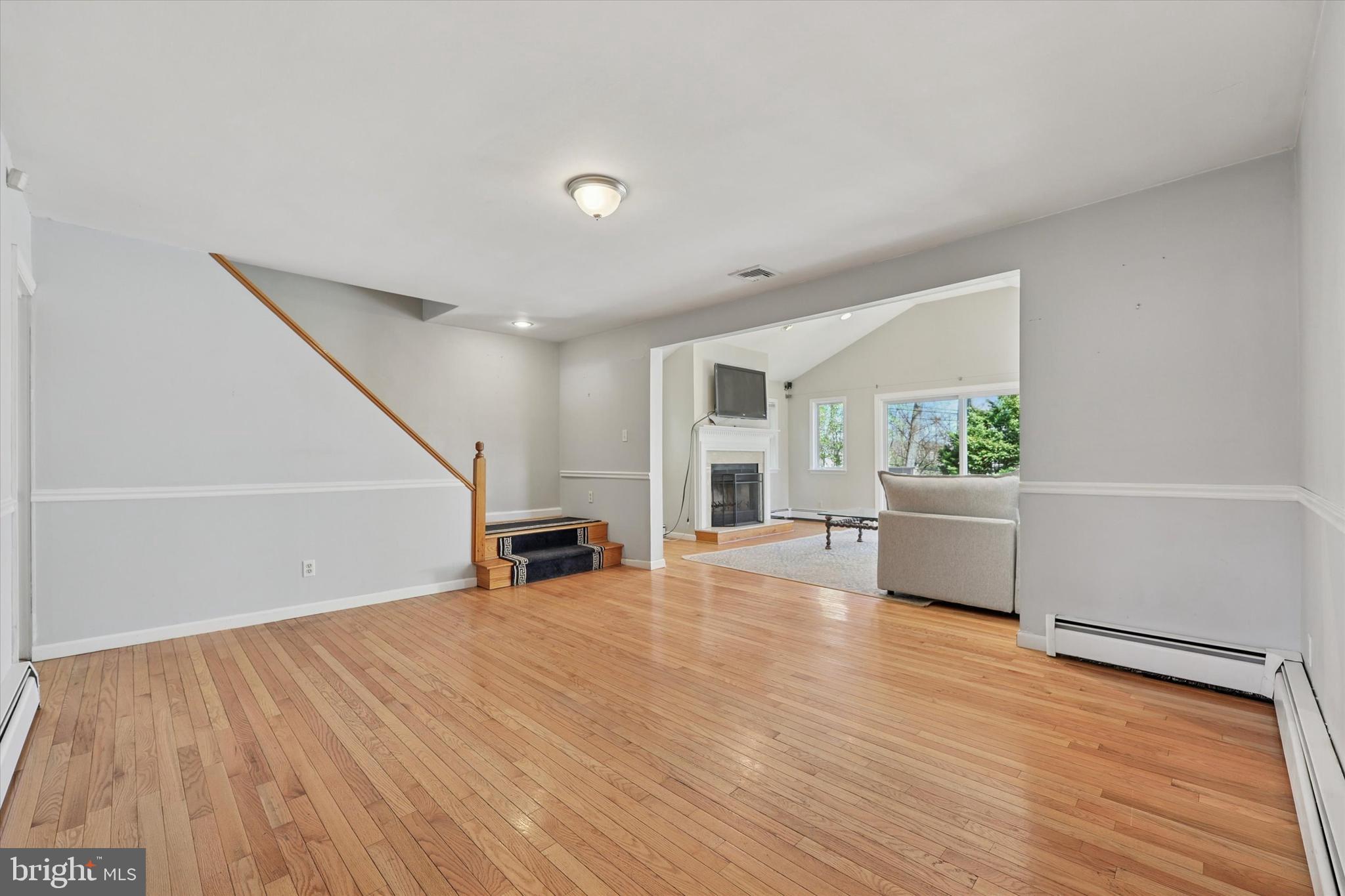 13 Devonwood Road Wayne, PA 19087 - Photo 7 of 24 a view of empty room with wooden floor and kitchen view