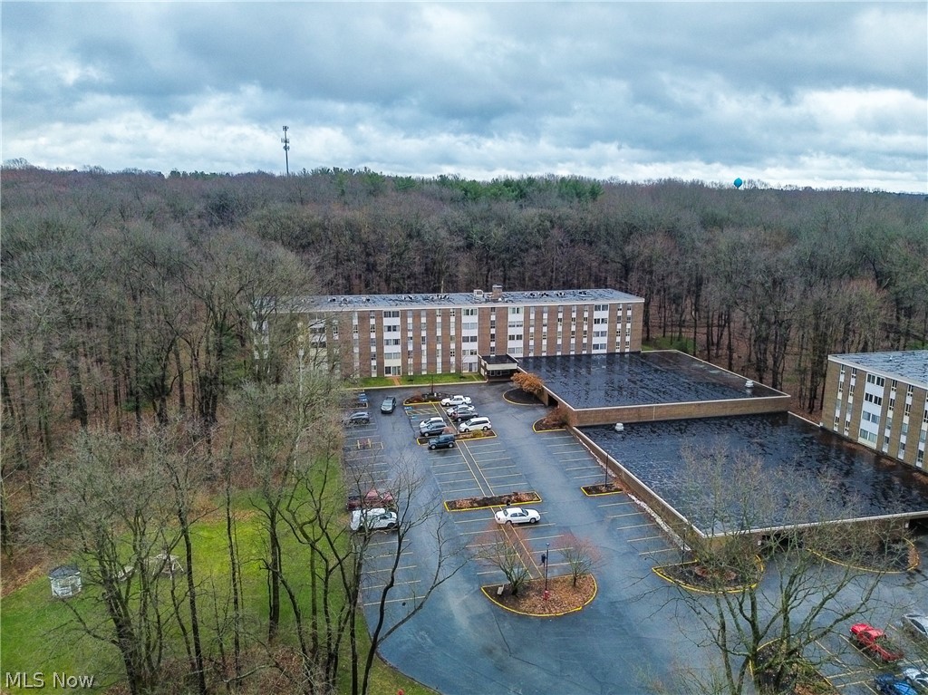 Aerial view of a heavily wooded area and condo complex / building