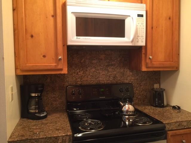 1977 Soda Ridge Road, Unit 1171 Keystone, CO 80435 - Photo 4 of 21 a kitchen with granite countertop white cabinets and black appliances