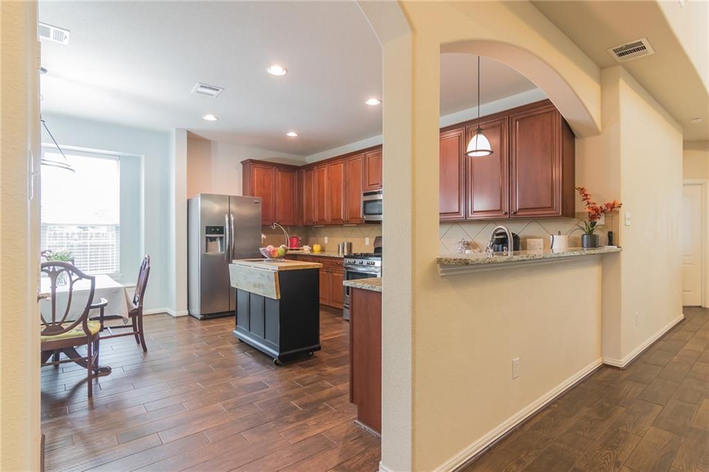 252 Pond View Pass Buda, TX 78610 - Photo 5 of 37 Kitchen featuring stainless steel appliances, dark wood-type flooring, decorative light fixtures, light stone countertops, and recessed lighting