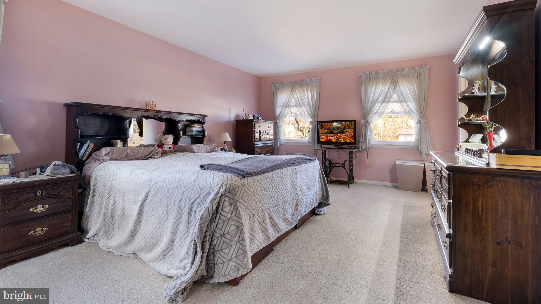 1267 Holly Road Warrington, PA 18976 - Photo 23 of 42 a spacious bedroom with a bed and a mirror
