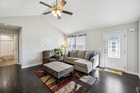 a living room with furniture a wooden floor and a chandelier