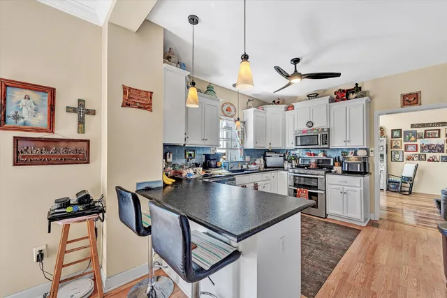 a kitchen with stainless steel appliances granite countertop a stove a sink dishwasher and a refrigerator with wooden floor