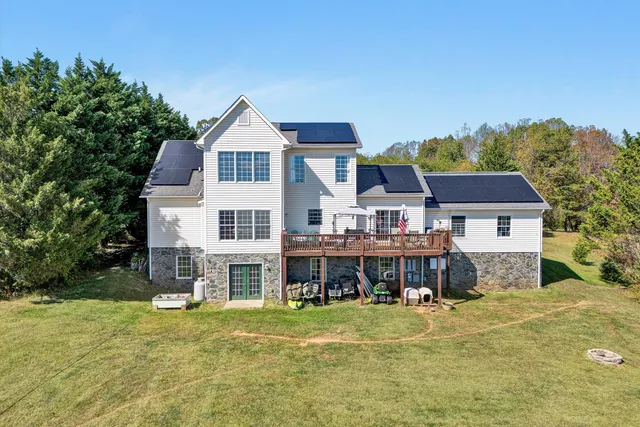 a view of a big house with a big yard and large trees