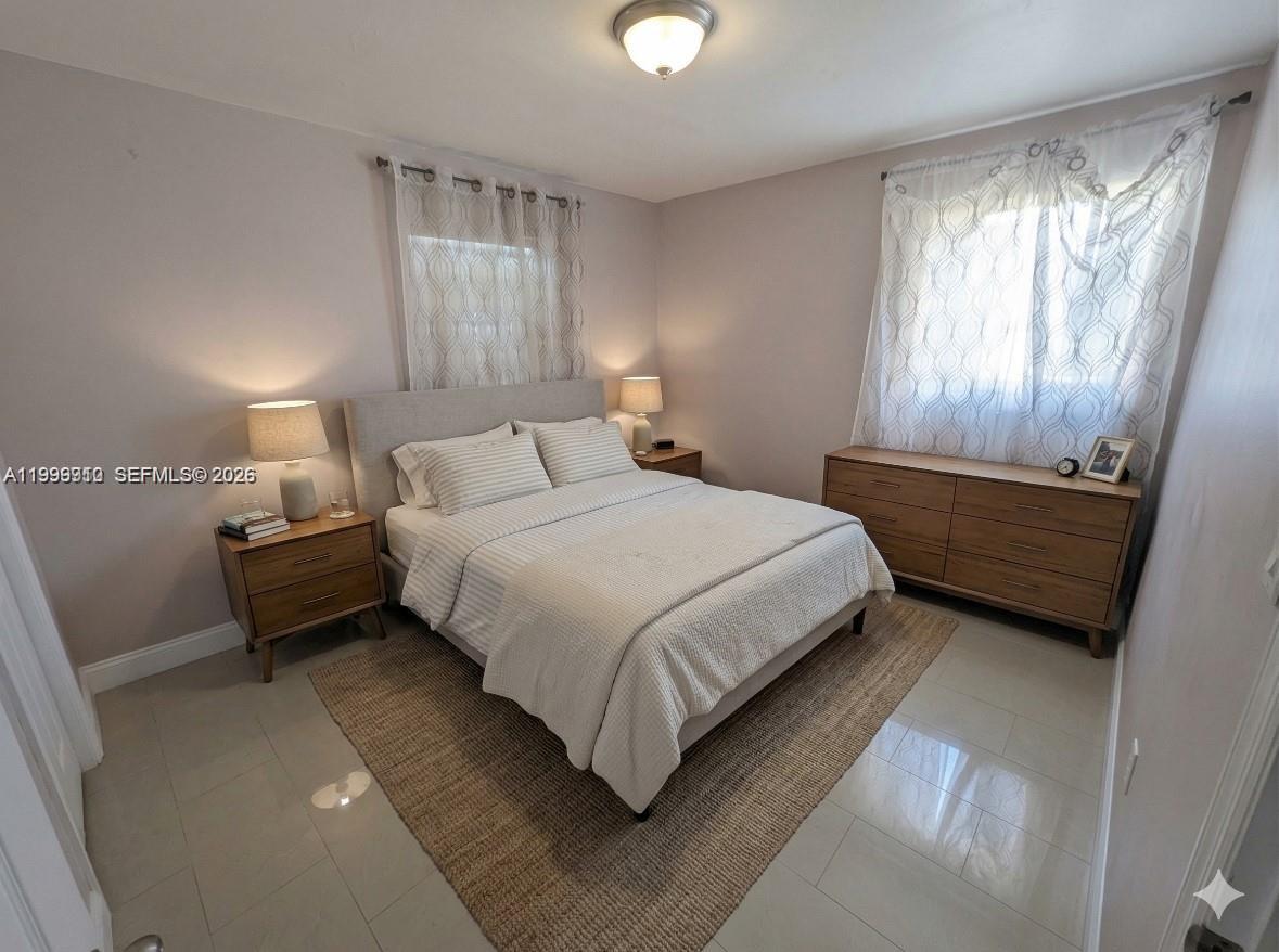 442 Northeast 162nd Street Miami, FL 33162 - Photo 4 of 9 a bedroom with a bed and window