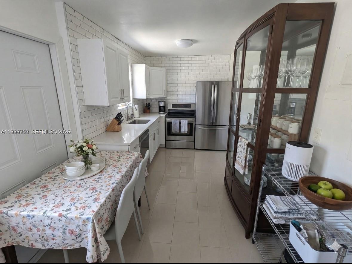 442 Northeast 162nd Street Miami, FL 33162 - Photo 6 of 9 a kitchen with sink refrigerator and stove