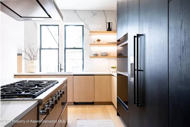 a kitchen with a stove a refrigerator and a window