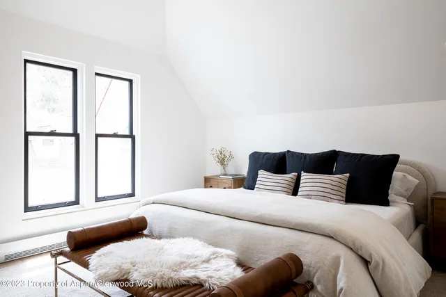 a bedroom with a bed and a large window