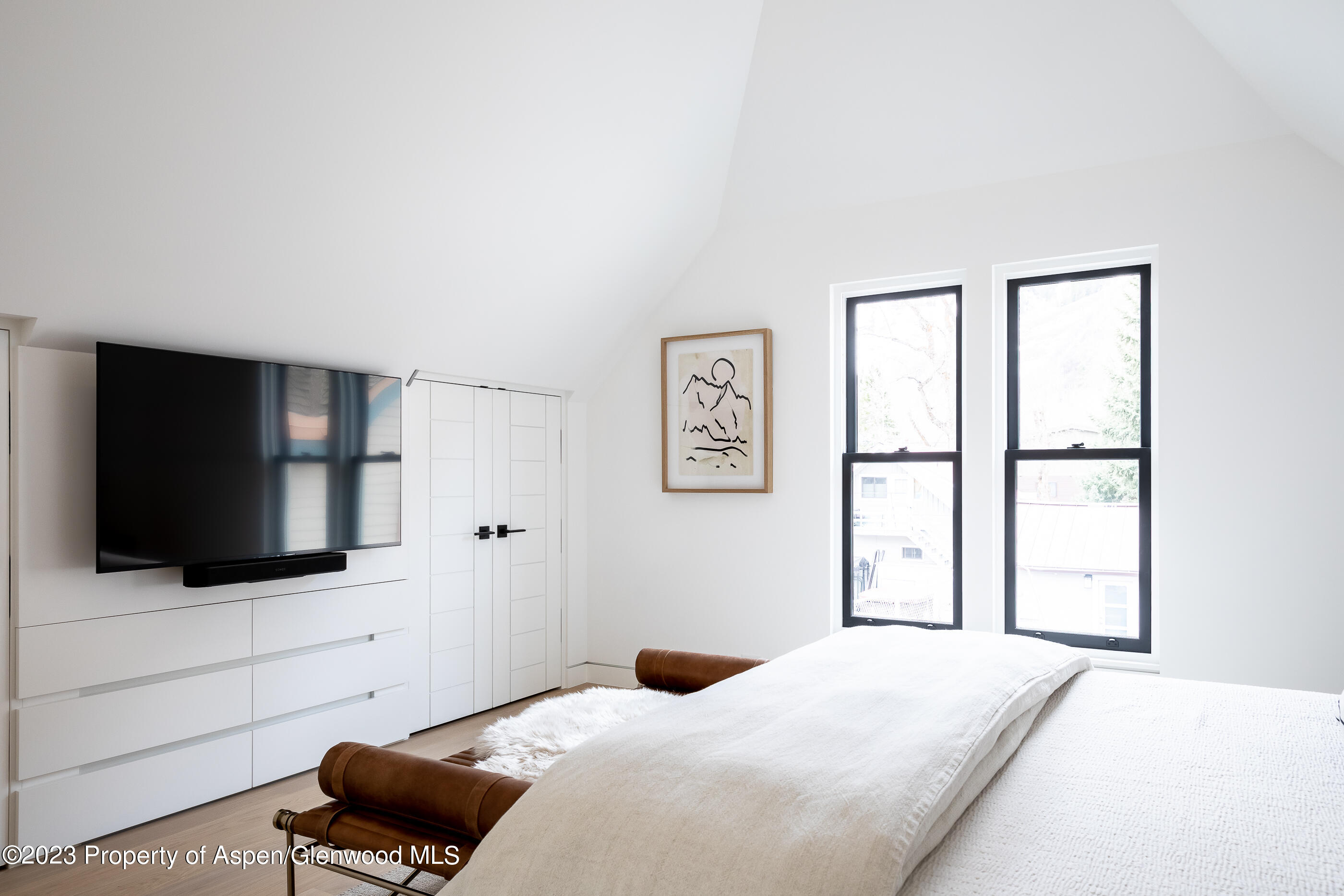 125 West Main Street Aspen, CO 81611 - Photo 29 of 52 a bedroom with a bed and a flat screen tv