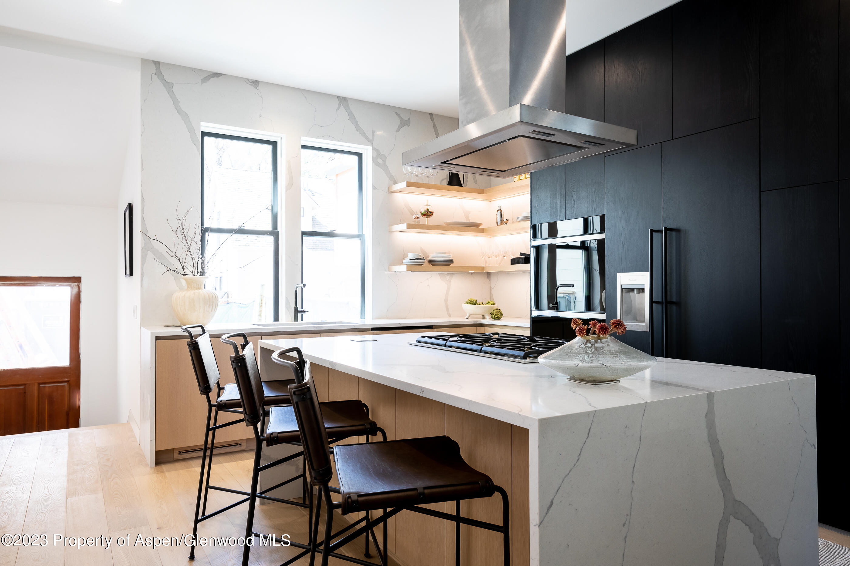 125 West Main Street Aspen, CO 81611 - Photo 10 of 52 a kitchen with a table chairs and a refrigerator