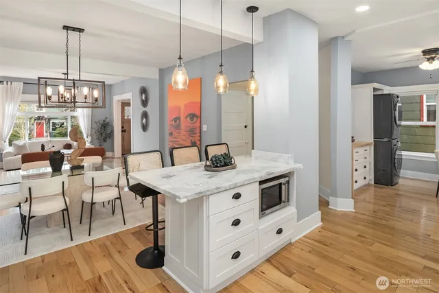 a kitchen with stainless steel appliances kitchen island a chandelier and wooden floor
