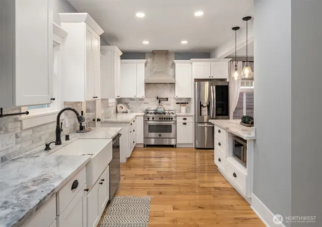 a kitchen with stainless steel appliances granite countertop a sink and a stove