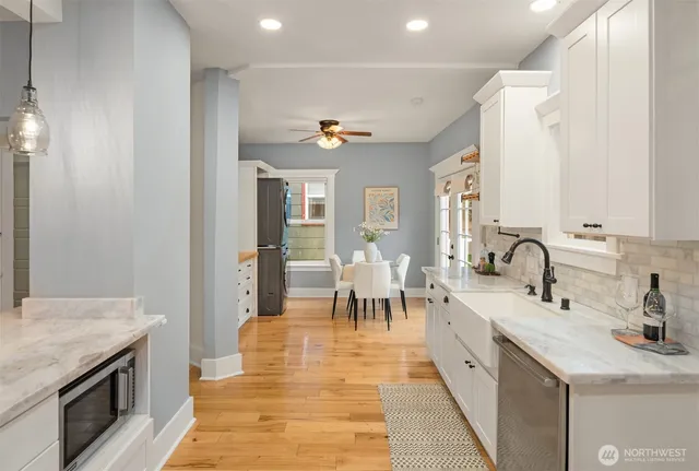a large kitchen with sink a counter space and stainless steel appliances