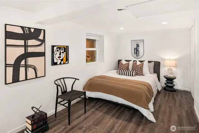 a bedroom with a bed and painting on the wall