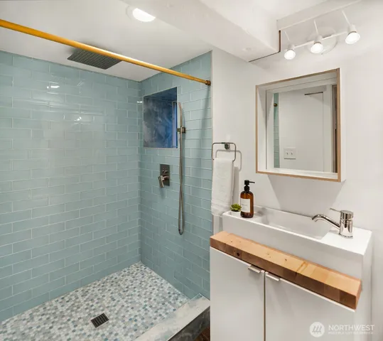 a bathroom with a sink a mirror and a shower