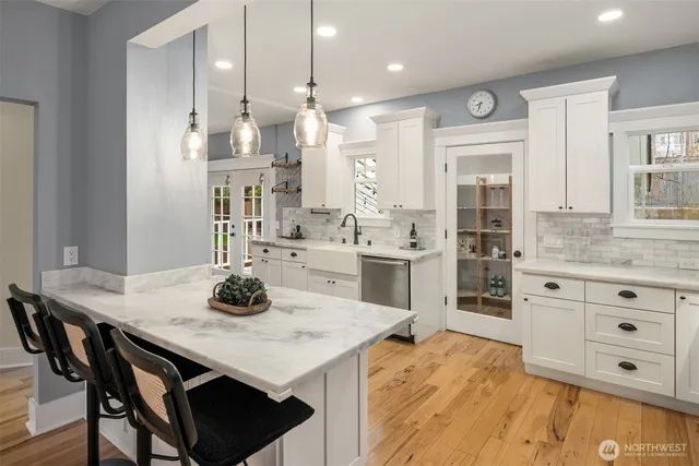 a kitchen with stainless steel appliances kitchen island granite countertop a sink cabinets and wooden floor