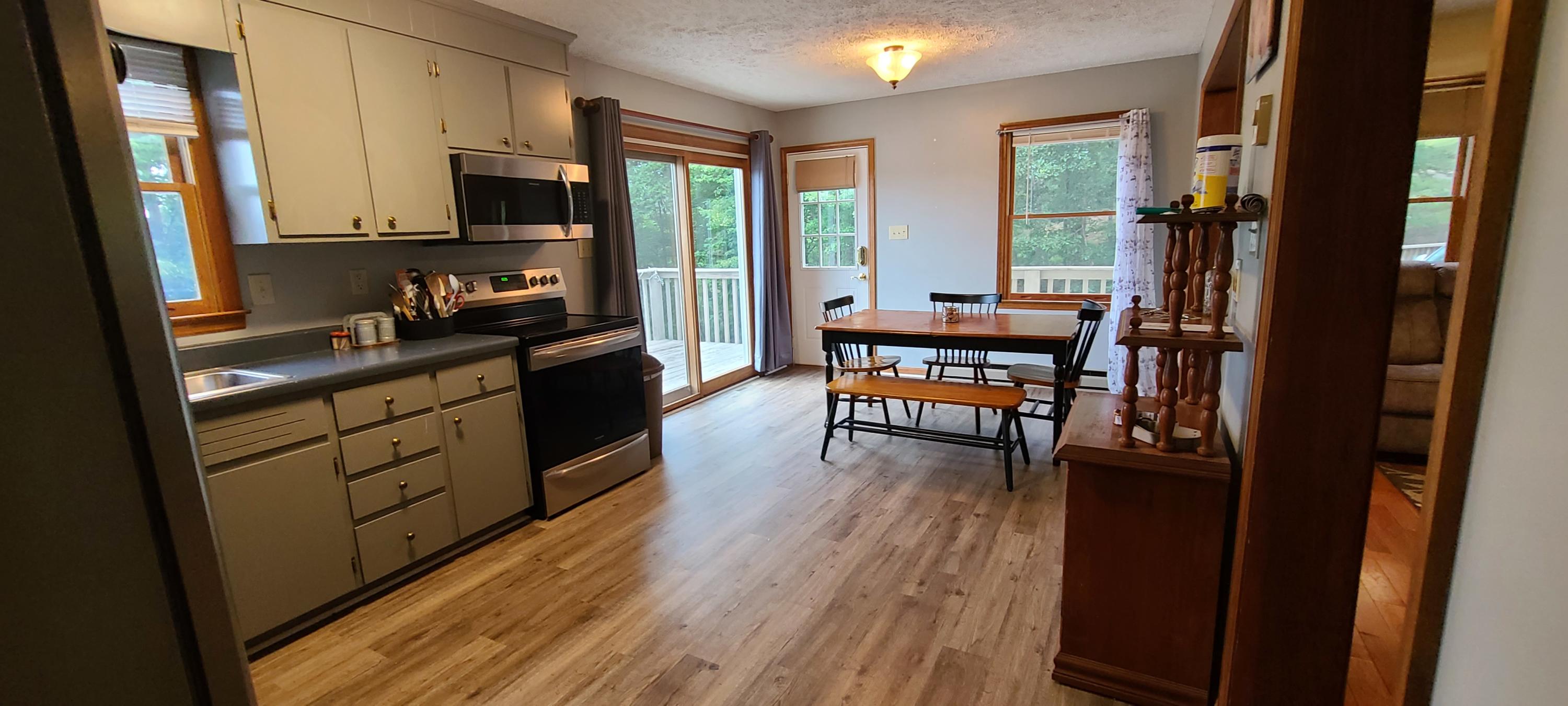 6331 Horseshoe Bend Road Goodview, VA 24095 - Photo 47 of 75 a kitchen with stainless steel appliances granite countertop sink stove refrigerator and wooden floor