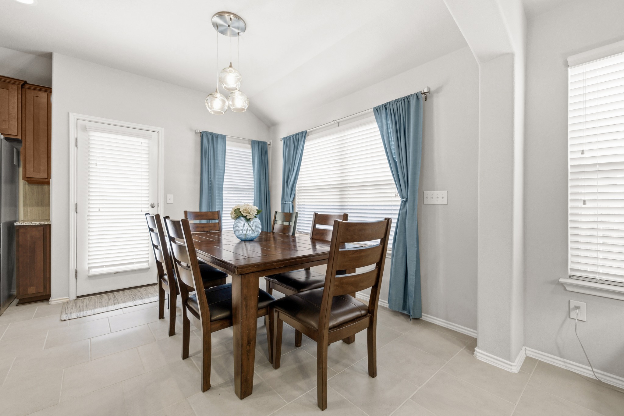 219 Noddy Road Buda, TX 78610 - Photo 19 of 31 Dining room featuring healthy amount of natural light, vaulted ceiling, and light tile patterned floors