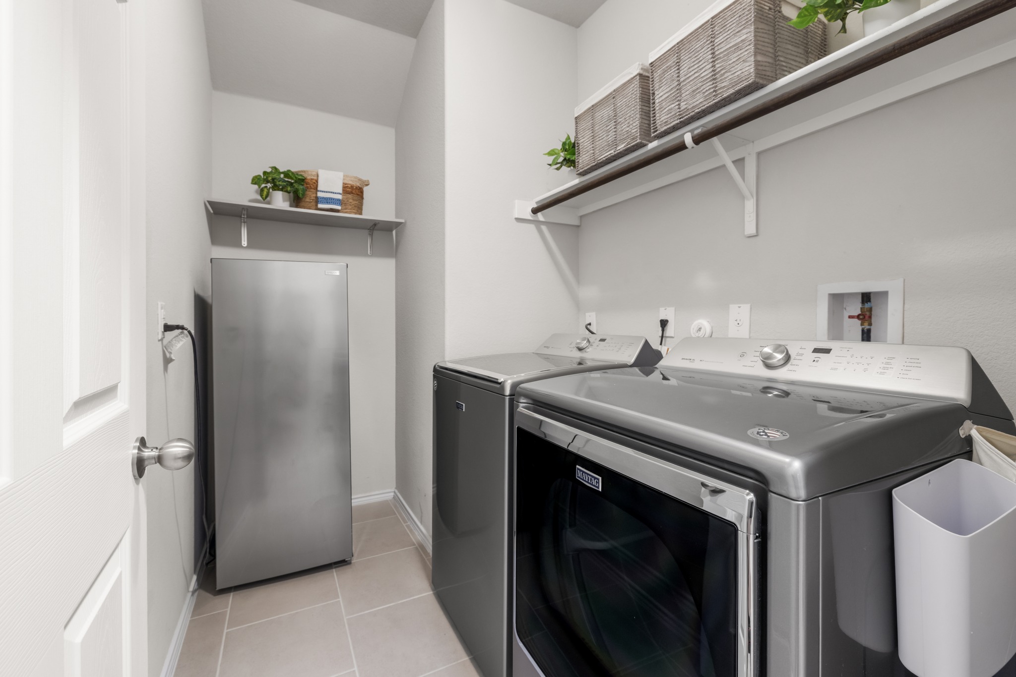 219 Noddy Road Buda, TX 78610 - Photo 27 of 31 Laundry area featuring washing machine and clothes dryer and light tile patterned floors