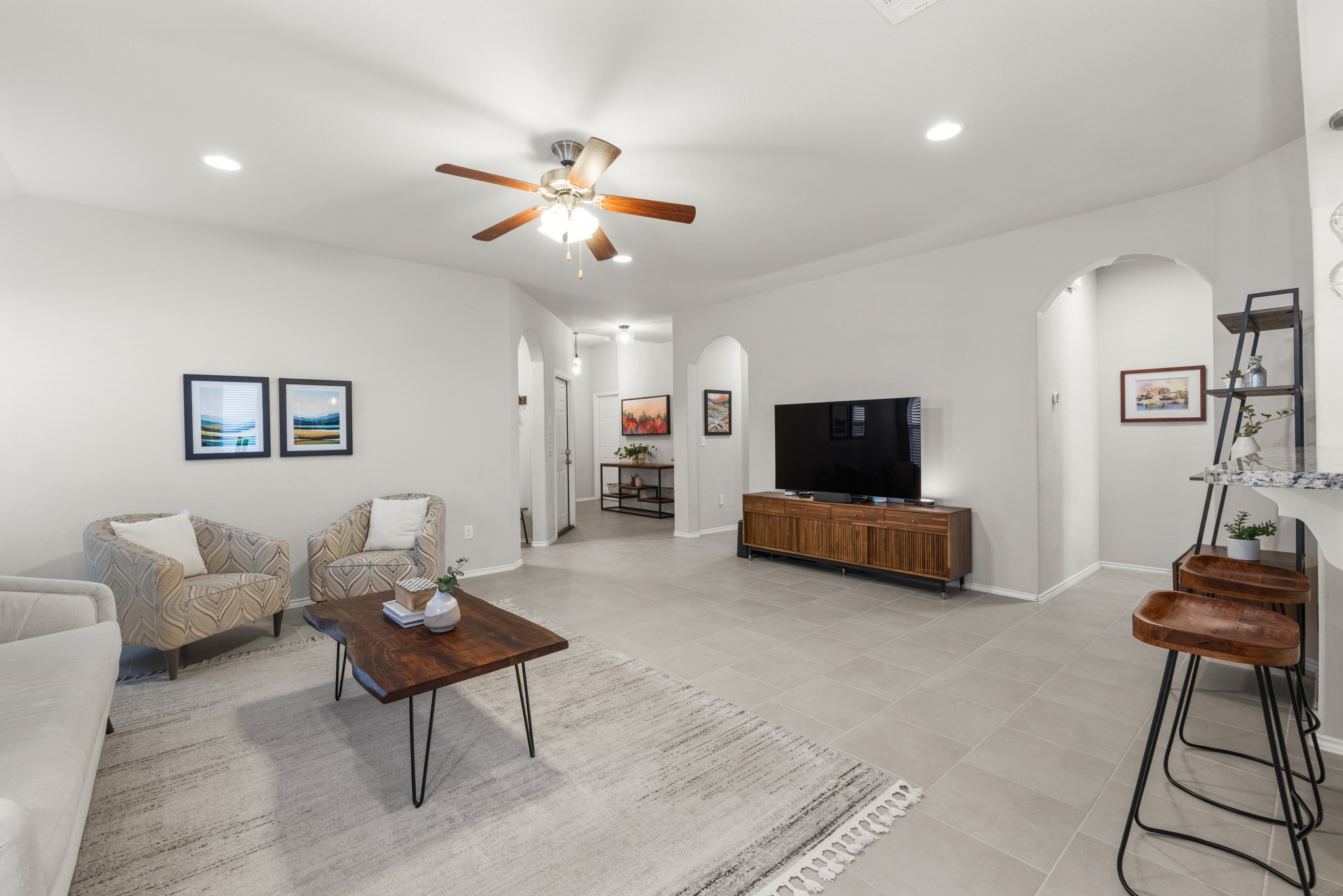 219 Noddy Road Buda, TX 78610 - Photo 8 of 31 Living area featuring arched walkways, ceiling fan, and recessed lighting