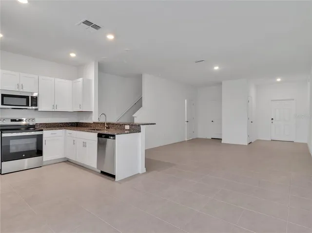 a kitchen with white cabinets and stainless steel appliances