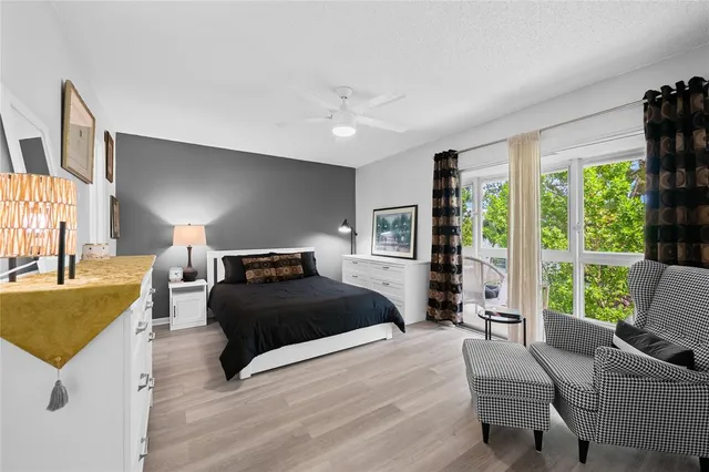 a bedroom with a bed couch and a large window