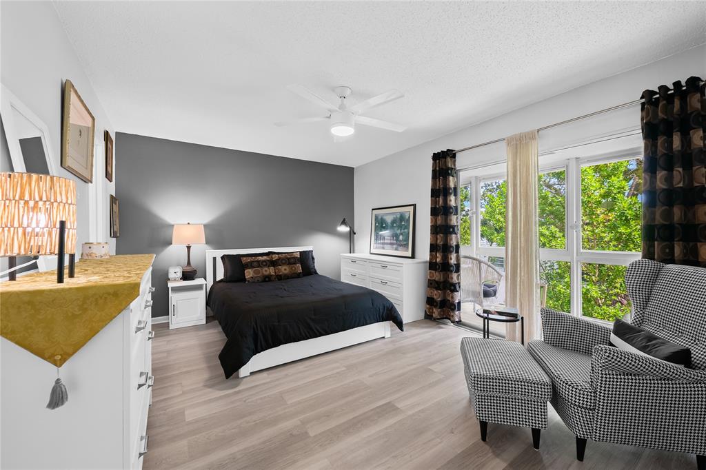 318 Oakridge R, Unit 318 Deerfield Beach, FL 33442 - Photo 13 of 26 a bedroom with a bed couch and a large window